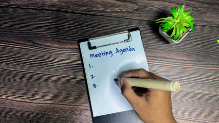 Concept of Meeting Agenda write on paperwork Supported by an additional services isolated on wooden background.の写真素材