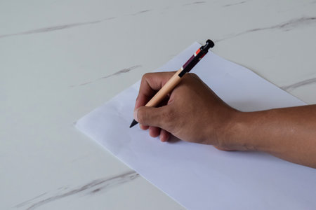 young man writing on blank paperの写真素材