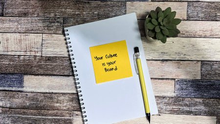 Concept of Your Culture is your brand write on sticky notes isolated on Wooden Table.の写真素材