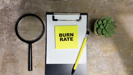 Concept of Burn Rate write on sticky notes isolated on Wooden Table.