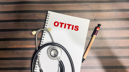 Concept of Otitis write on book isolated on Wooden Table.