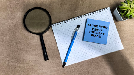 Concept of At The Right Time In The Right Place write on sticky notes isolated on Wooden Table.の写真素材