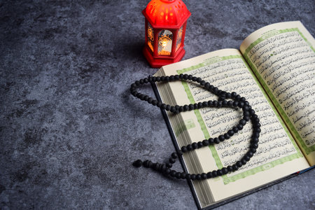 The holy quran, prayer beads, golden ramadhan lamp with islamic rosary beads on dark background ramadhan. Islamic conceptの写真素材
