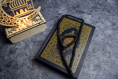 The holy quran, prayer beads, golden ramadhan lamp with islamic rosary beads on dark background ramadhan. Islamic conceptの写真素材