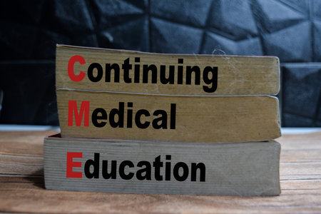 Books with words Continuing Medical Education on wooden table and black backgroundの写真素材