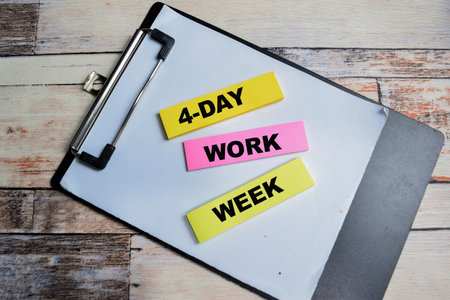 Concept of 4 Day Work Week write on sticky notes isolated on Wooden Table.の写真素材