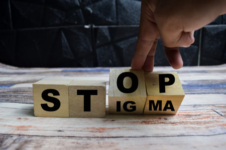 Concept word Stop stigma symbol, doctor turns with words stop stigma on wooden blocks on a wooden tableの写真素材