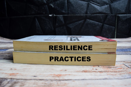 Books with words Resilience practice on wooden table and black backgroundの写真素材