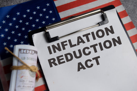 Concept of Inflation Reduction Act write on paperwork with United States flag isolated on Wooden...