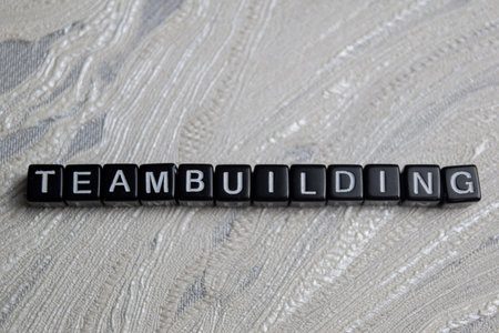 Concept of Team building written on wooden blocks. Cross processed image on Wooden Background