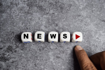 male hand presses the play button with news on dice or wooden cubesの写真素材