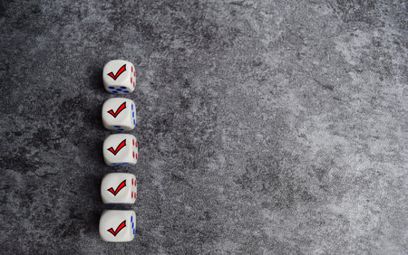 Wooden cubes or dice with check mark on the table. Checklist concept