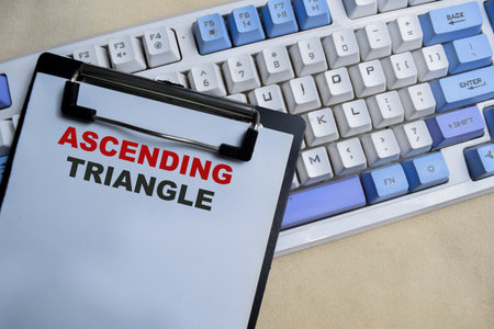 Concept of Ascending triangle write on clipboard isolated on Wooden Table.の写真素材