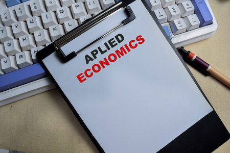 Concept of economics write on clipboard isolated on Wooden Table.の写真素材