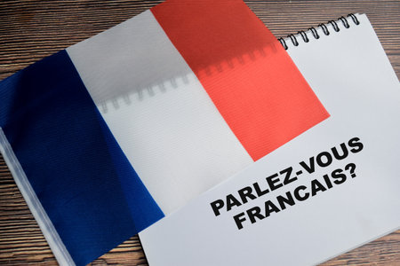 Concept of with question parlez-vous francais write on book and flag of french isolated on Wooden Table.の写真素材