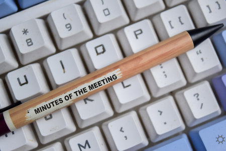 Text Minutes of the meeting on wooden pencil isolated on white keyboardの写真素材