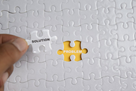 Hand holding piece of jigsaw puzzle with word solution problem. Business and finance concept