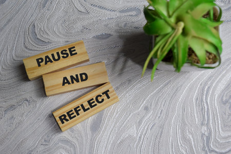 Concept of Pause and Reflect Symbol. Wooden block with words pause and reflect