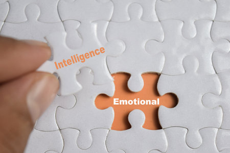 Hand holding piece of jigsaw puzzle with word Emotional Intelligence. Business and finance conceptの写真素材