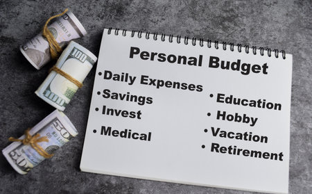 Concept of Personal budget write on book. with dollars inside on the tableの写真素材