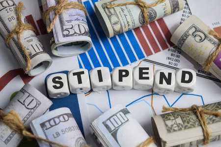 The word stipend on stacked wooden cubes on the table. Business and finance conceptの写真素材