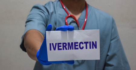 A doctor man holding paper with text Ivermectin