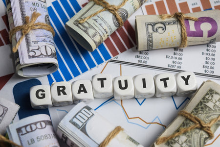 The word Gratuity on stacked wooden cubes on the table. Business and finance concept
