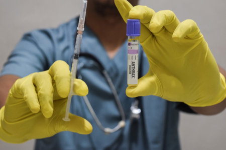 Text Anthrax vaccine of is written on a bottle with background of a doctor with a syringe in a medical glove mask. Medical conceptの写真素材