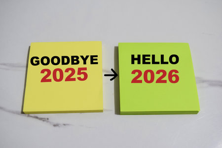 Concept of Goodbye 2025 to Hello 2026 write on sticky notes isolated on Wooden Table.の写真素材