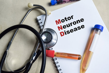 Concept of Motor Neurone Disease - MND write on book isolated on Wooden Table. healthcare or Medical conceptの写真素材