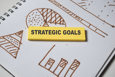 Concept of Strategic goals write on sticky notes isolated on Wooden Table. stock and chart business conceptの写真素材
