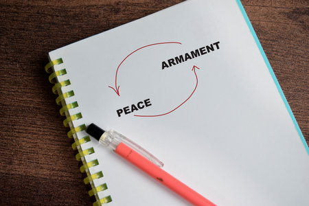 Concept cycle of peace and armanent write on book isolated on Wooden Table.の写真素材