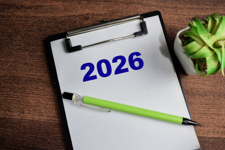 Concept of 2026 write on clipboard isolated on Wooden Table.