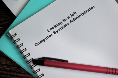 Concept of looking for a job computer systems administrator write on book isolated on Wooden Table.