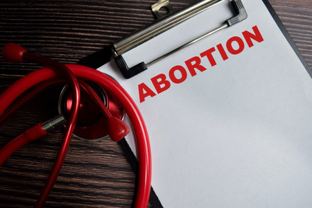 Concept of ABORTION write on clipboard isolated on Wooden Table.の写真素材
