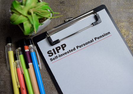 Concept of SIPP - Self-Invested Personal Pension write on clipboard isolated on Wooden Table.の写真素材