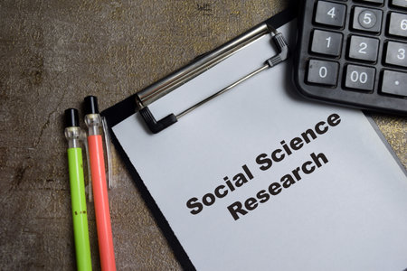 Concept of Social Science Research write on clipboard isolated on Wooden Table.
