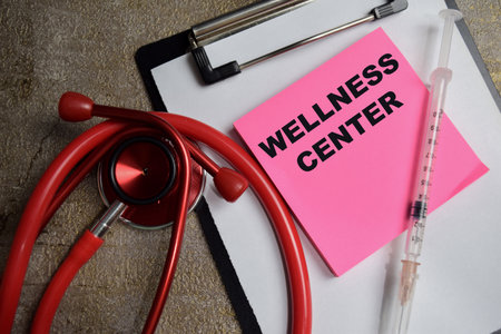 Concept of Wellness Center write on sticky notes isolated on Wooden Table. healthcare and pharmaceutical concept