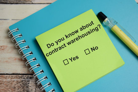 Do you know about contract warehousing write on sticky notes isolated on Wooden Table. A person is...