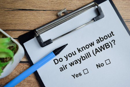 Do you know about air waybill - AWB write on clipboard isolated on Wooden Table. A person is...