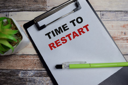 Concept of Time to restart write on clipboard isolated on Wooden Table.