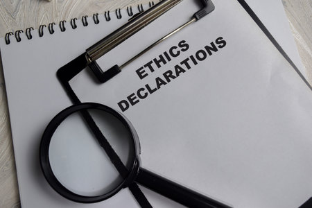 Concept of Ethics declarations write on clipboard isolated on Wooden Table.