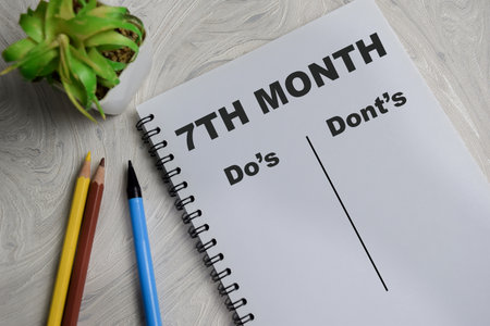 Concept of 7th month do's and dont's write on book isolated on Wooden Table.