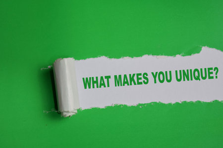 What makes you unique? Text written in torn paperの写真素材