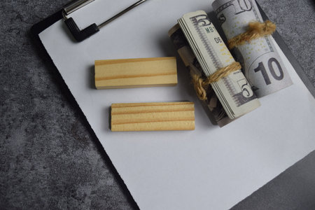 Concept of dollar above on clipboard isolated on Wooden Table.の写真素材