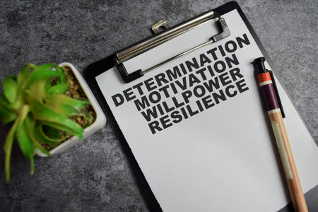 Concept of Determination Motivation Willpower Resilience write on clipboard isolated on Wooden Table.の写真素材