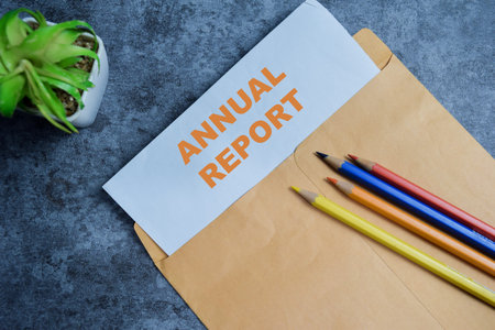 Annual report text on document above brown envelope.