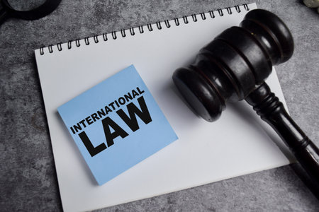 Concept of international law on sticky notes isolated on Wooden Table.