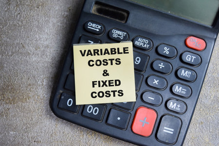 Concept of Variable costs and fixed costs write on sticky notes isolated on Wooden Table.