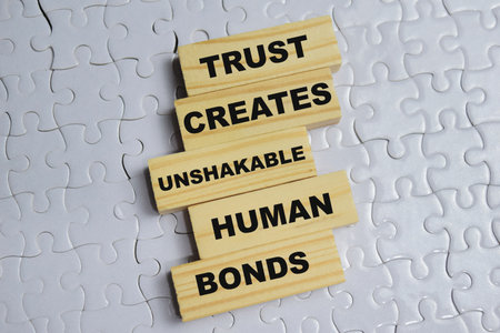 Trust creates unshakable human bonds on stacked wooden cubes on the table.
